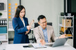 © Nuttapong punna - Furious two Asian businesspeople arguing strongly after making a mistake at work in office..