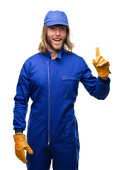 Canvas Print - Young handsome mechanic man with long hair over isolated background pointing finger up with successful idea. Exited and happy. Number one.