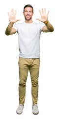 Canvas Print - Handsome man wearing casual white t-shirt showing and pointing up with fingers number ten while smiling confident and happy.