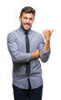 © Krakenimages.com - Young handsome business man over isolated background smiling with happy face looking and pointing to the side with thumb up.