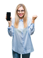 Wall Mural - Young beautiful blonde business woman showing screen of smartphone over isolated background screaming proud and celebrating victory and success very excited, cheering emotion