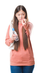 Canvas Print - Young Chinese woman over isolated background wearing sport sweathshirt pointing with finger to the camera and to you, hand sign, positive and confident gesture from the front