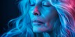 © inspiretta - A woman with blue hair and a blue face. She is looking at the camera. The image has a cool, futuristic vibe