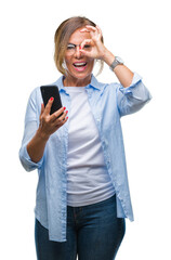 Canvas Print - Middle age senior woman texting sending message using smartphone over isolated background with happy face smiling doing ok sign with hand on eye looking through fingers