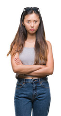 Canvas Print - Young asian woman wearing sunglasses over isolated background skeptic and nervous, disapproving expression on face with crossed arms. Negative person.