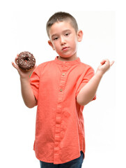 Poster - Dark haired little child eating doughnut very happy pointing with hand and finger to the side