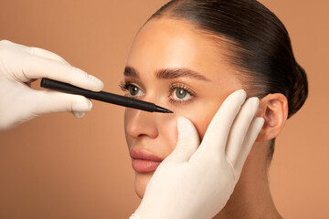 Plastic surgeon drawing lines under female patient eye. Plastic surgery, beauty portrait, closeup