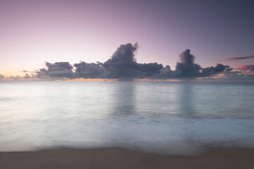 Long exposure sea view sunrise in Brazil with clouds on horizon