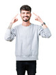 © Krakenimages.com - Young handsome man wearing sweatshirt over isolated background Smiling pointing to head with both hands finger, great idea or thought, good memory
