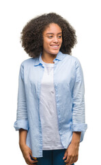 Sticker - Young afro american woman over isolated background looking away to side with smile on face, natural expression. Laughing confident.