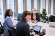© Johnér - Smiling businesswomen looking away over conference table in office