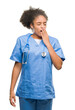 © Krakenimages.com - Young afro american doctor woman over isolated background bored yawning tired covering mouth with hand. Restless and sleepiness.