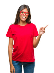 Sticker - Young asian woman wearing glasses over isolated background with a big smile on face, pointing with hand and finger to the side looking at the camera.