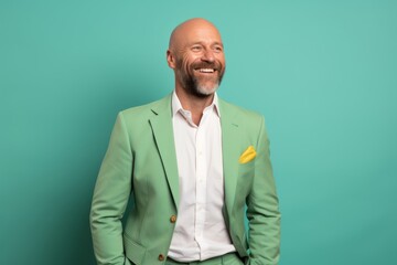 Poster - Portrait of a cheerful man in his 40s wearing a professional suit jacket isolated in pastel green background