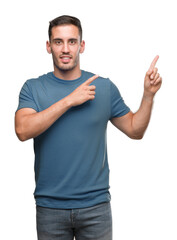 Canvas Print - Handsome young casual man smiling and looking at the camera pointing with two hands and fingers to the side.