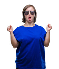 Sticker - Young adult woman with down syndrome wearing sunglasses over isolated background celebrating mad and crazy for success with arms raised and closed eyes screaming excited. Winner concept