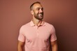 © Markus Schröder - Portrait of a cheerful man in his 30s wearing a sporty polo shirt on pastel brown background