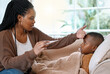 © peopleimages.com - Forehead, sick and mom with child in bed with allergy, cold and flu in home with worried single parent. Illness, African mother or hand on son for temperature check for fever with thermometer or care