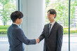 © rrice - 握手をするビジネスマン