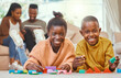 © peopleimages.com - Portrait, happy children and building blocks on floor in living room for development, learning or educational game. Black family, young kids with parents for fun, playing or bonding together in home