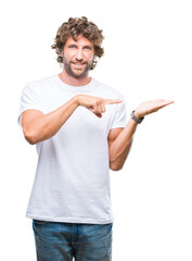 Wall Mural - Handsome hispanic model man over isolated background amazed and smiling to the camera while presenting with hand and pointing with finger.