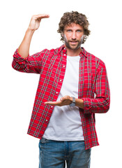 Poster - Handsome hispanic model man over isolated background gesturing with hands showing big and large size sign, measure symbol. Smiling looking at the camera. Measuring concept.