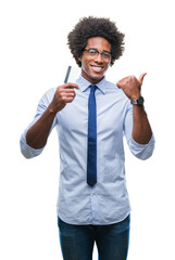 Wall Mural - afro american man holding credit card over isolated background pointing and showing with thumb up to