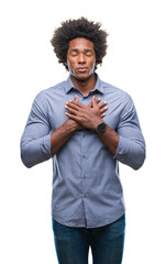 Wall Mural - Afro american man over isolated background smiling with hands on chest with closed eyes and grateful gesture on face. Health concept.