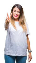 Wall Mural - Young beautiful woman casual white t-shirt over isolated background showing and pointing up with fingers number two while smiling confident and happy.