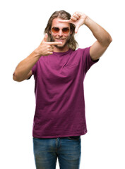 Sticker - Young handsome man with long hair wearing sunglasses over isolated background smiling making frame with hands and fingers with happy face. Creativity and photography concept.