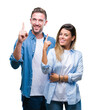 © Krakenimages.com - Young couple in love over isolated background pointing finger up with successful idea. Exited and happy. Number one.