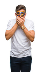 Canvas Print - Young handsome man wearing carnival mask over isolated background shocked covering mouth with hands for mistake. Secret concept.