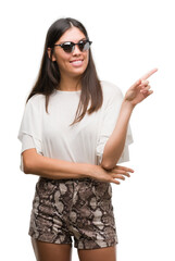 Wall Mural - Young beautiful hispanic wearing sunglasses very happy pointing with hand and finger to the side