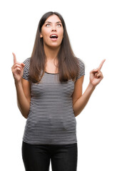 Poster - Young beautiful hispanic woman amazed and surprised looking up and pointing with fingers and raised arms.