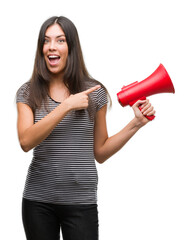 Sticker - Young hispanic woman holding megaphone very happy pointing with hand and finger