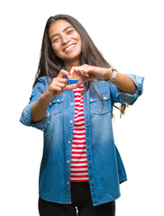 Wall Mural - Young beautiful arab woman over isolated background smiling in love showing heart symbol and shape with hands. Romantic concept.