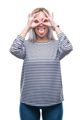 Sticker - Young blonde woman over isolated background doing ok gesture like binoculars sticking tongue out, eyes looking through fingers. Crazy expression.