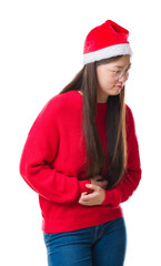 Canvas Print - Young Chinese woman over isolated background wearing christmas hat with hand on stomach because nausea, painful disease feeling unwell. Ache concept.