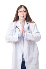 Sticker - Young Chinese doctor woman over isolated background begging and praying with hands together with hope expression on face very emotional and worried. Asking for forgiveness. Religion concept.