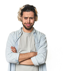 Young Caucasian man in studio setting unhappy looking in camera with sarcastic expression.