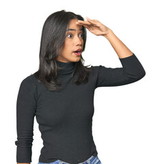 Wall Mural - simple portrait of a young latina looking far away keeping hand on forehead.