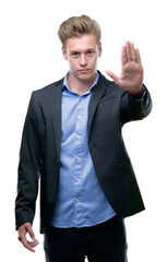 Poster - Young handsome blond business man with open hand doing stop sign with serious and confident expression, defense gesture