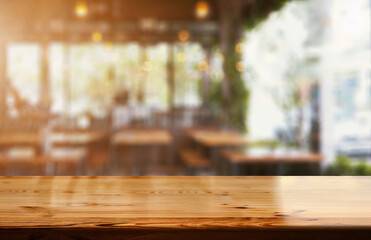 Poster - Empty wooden tabletop with blurred restaurant or coffee shop background for product display