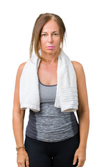 Wall Mural - beautiful middle age woman wearing sport clothes and a towel over isolated background with serious e