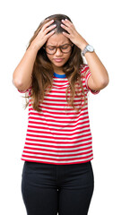 Wall Mural - Young beautiful brunette woman wearing glasses and stripes t-shirt over isolated background suffering from headache desperate and stressed because pain and migraine. Hands on head.