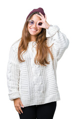 Sticker - Young beautiful brunette hipster woman wearing sunglasses over isolated background doing ok gesture with hand smiling, eye looking through fingers with happy face.