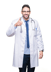 Poster - Handsome young doctor man over isolated background doing happy thumbs up gesture with hand. Approving expression looking at the camera showing success.