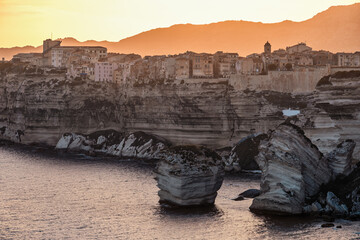 Sticker - Sun setting over the citadel of Bonifacio perched above limestone cliffs and the Mediterranean sea on the south coast of the island of Corsica