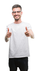 Poster - Young tattooed adult man approving doing positive gesture with hand, thumbs up smiling and happy for success. Looking at the camera, winner gesture.