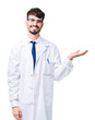 © Krakenimages.com - Young professional scientist man wearing white coat over isolated background smiling cheerful presenting and pointing with palm of hand looking at the camera.